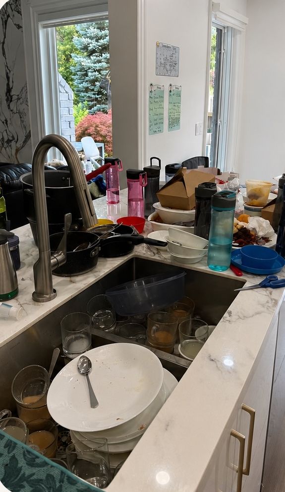 Kitchen sink full of dishes before cleaning